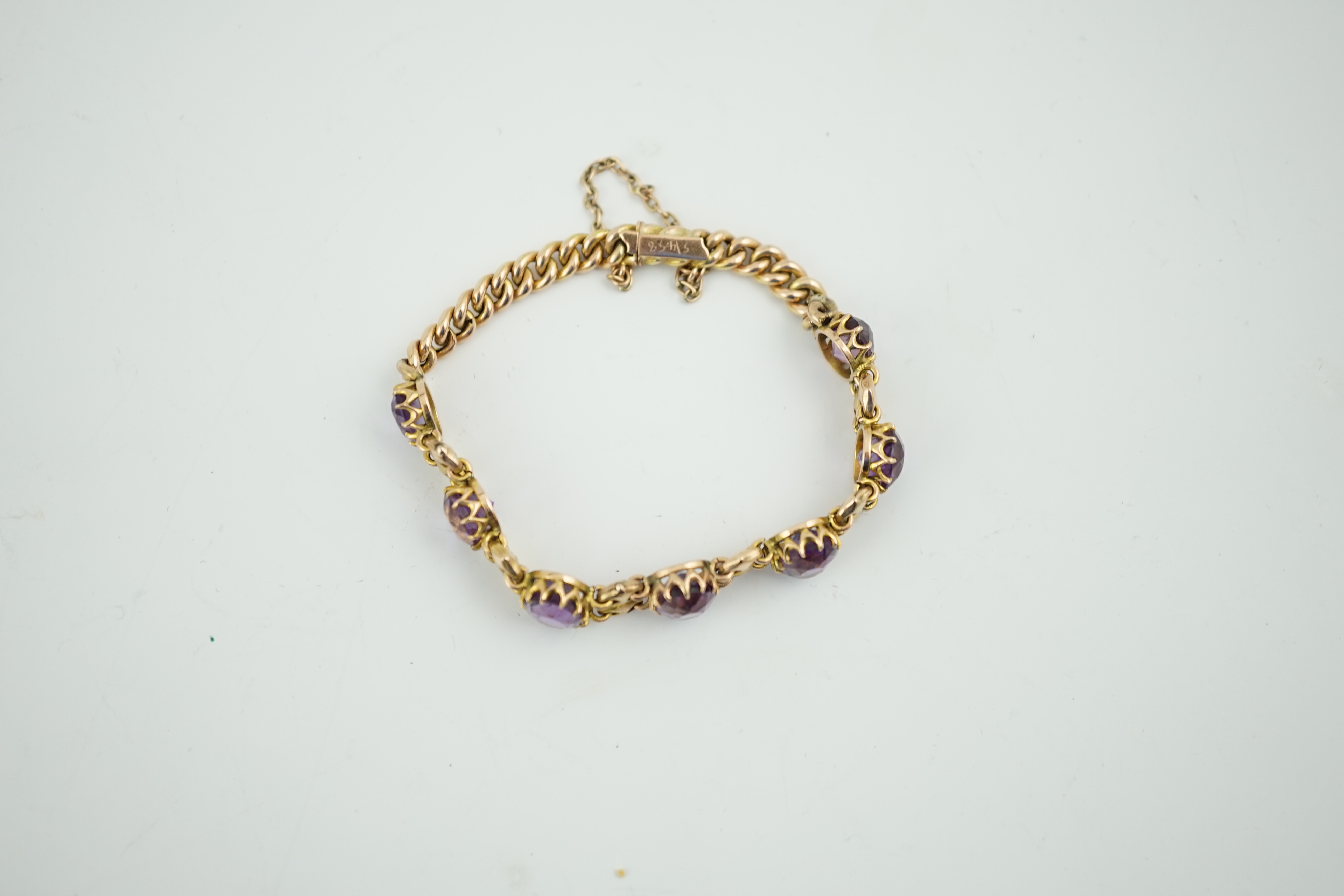 A 9ct gold and graduated seven stone oval cut amethyst set curb link bracelet